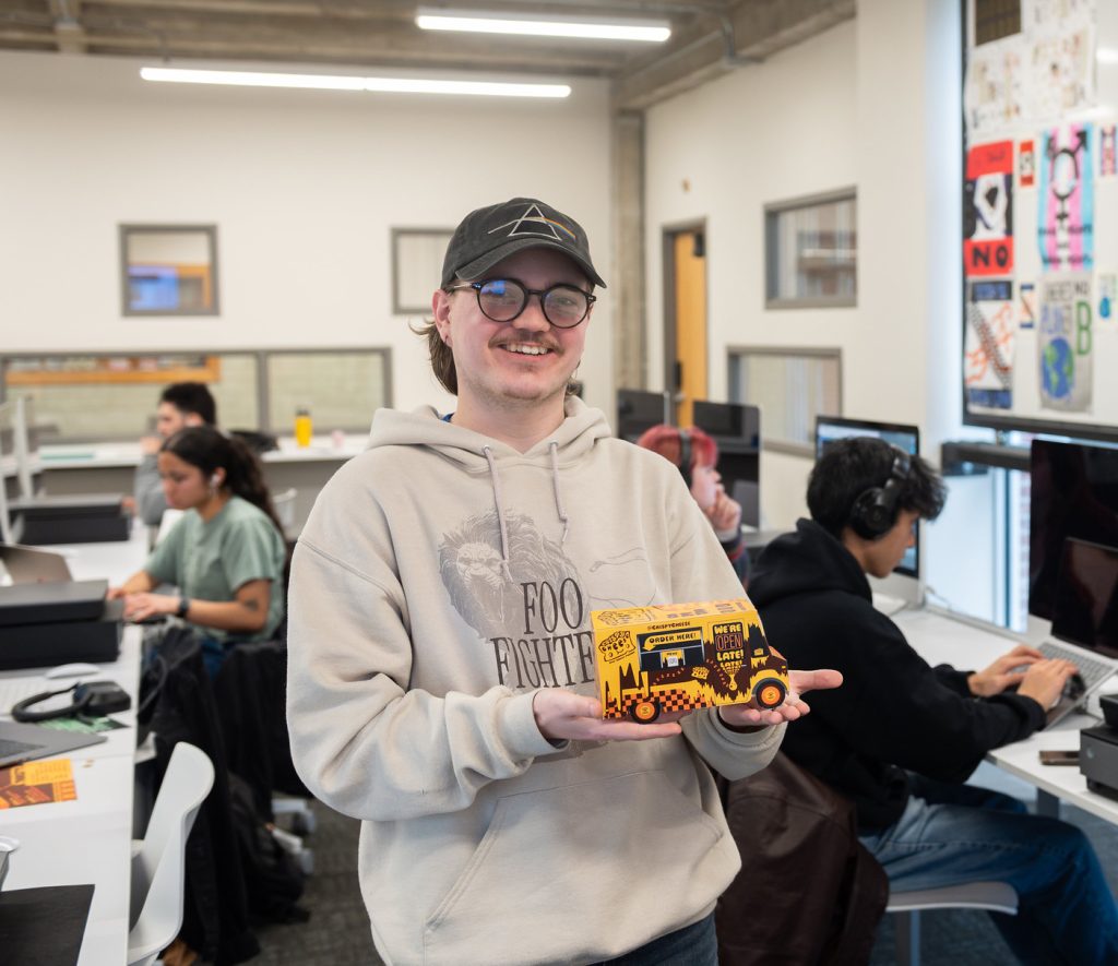 Student holding the food truck model they made